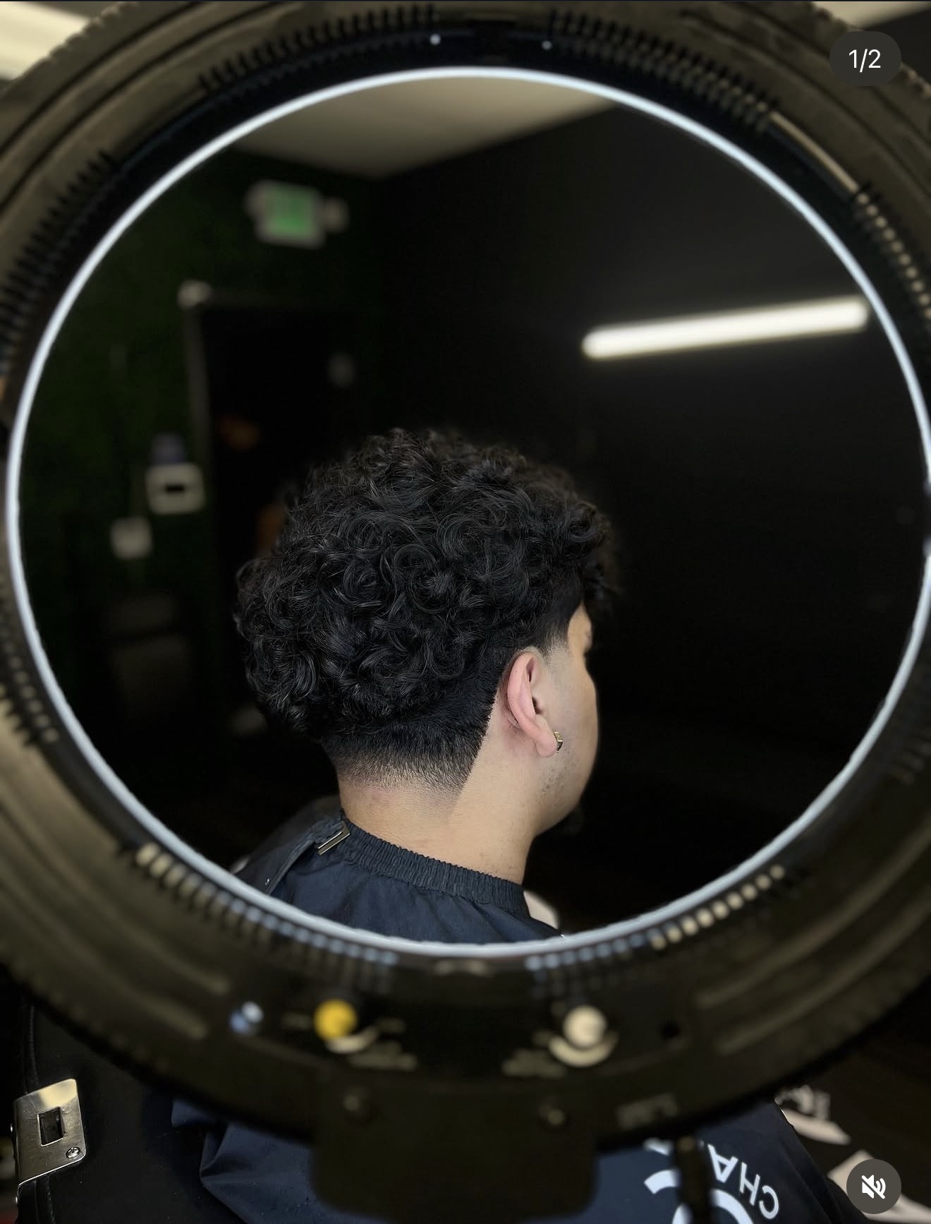 Curly taper fade viewed through the ring light mirror